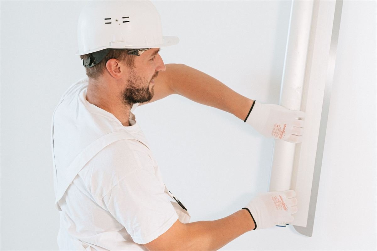 Professional drywall technician finishing a wall
